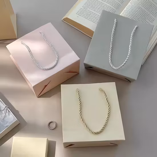 Saco de papel Kraft para compras de presente de luxo barato por atacado de fábrica OEM com logotipo personalizado